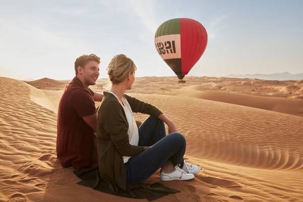happy couple in the desert with baloon dubai desert