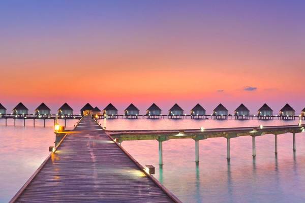 maledives twilight jetty huts sea